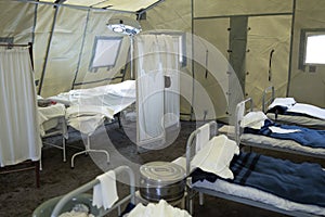 Inside a tent mobile military hospital, empty beds