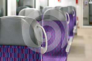 Inside the train wagon. Empty comfortable and colorful chairs in a modern electric train.