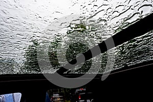 Inside a vehicle looking up to a sunroof with water droplets