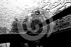 Inside a vehicle looking up to a sunroof with water droplets