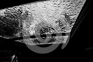 Inside a vehicle looking up to a sunroof with water droplets