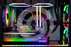 Inside view black high end custom colorful illuminated bright rainbow RGB LED gaming pc. Computer power hardware and technology