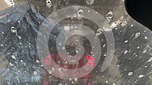 Inside view of a car being washed on an automatic machine. Automatic car washing from inside, tunnel car washing.