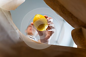 Inside view of craft paper bag with woman puts food in it. Food take away concept