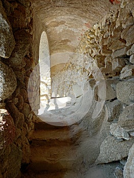 Inside view of luminous stone cave. Passage through tunnel in rock cave. Archeology and hiking