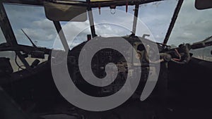 Inside view military abandoned plane cabin dusty dashboard cockpit interior. Control panel cargo helicopter standing on