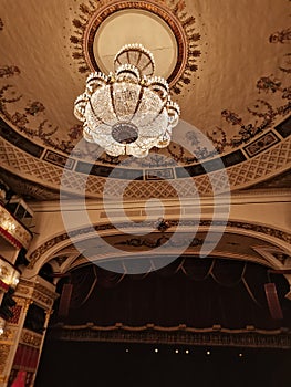 Inside view of royal box of alexandria theater red golden details rows performance chandelier rows