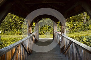 Inside vintage wood covered bridge. surrounded by colorful autumn leaves forest background. Old wooden building architecture.