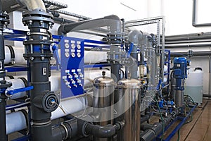 Inside of wastewater treatment facility with water pipes and many manometer indicators, sensors, sampler and rotameters