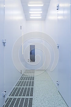 Inside white sterile clean room .Hallway with raised floor and door in clean room for pharmaceutical or electronic