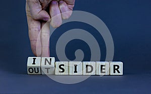 Insider or outsider symbol. Businessman turns a cube, changes the word `insider` to `outsider` or vice versa. Beautiful grey t