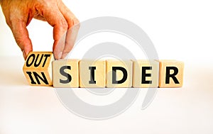 Insider or outsider symbol. Businessman turns wooden cubes and changes the concept word Insider to Outsider. Beautiful white table