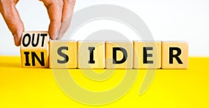 Insider or outsider symbol. Businessman turns wooden cubes and changes the concept word Insider to Outsider. Beautiful yellow