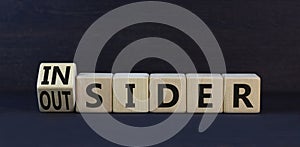 Insider or outsider symbol. Turned wooden cubes and changed the concept word Insider to Outsider. Beautiful black table black