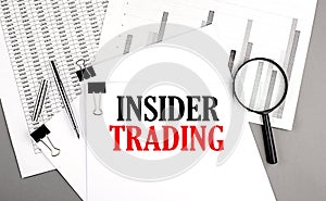 INSIDER TRADING text on paper on chart background