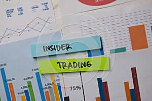 Insider Trading write on sticky notes with graphic on the paper isolated on office desk