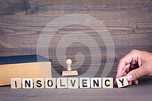 Insolvency. Wooden letters on dark background