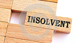 INSOLVENT word written on wood block. INSOLVENT text on table, concept.Business photo text make something more modern or up to photo
