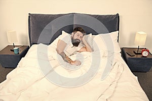 Insomnia. Sleep disorders concept. Man bearded hipster having problems with sleep. Guy lying in bed try to relax and