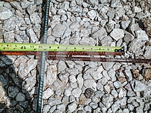Inspecting and documenting the rebar overlap with a measuring tape at a construction job site