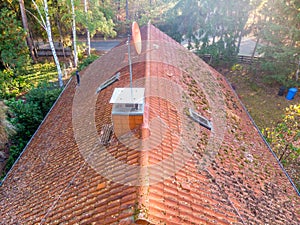 Inspection of the red tiled roof of a single-family house, inspection of the condition of the tiles on the roof of a detached
