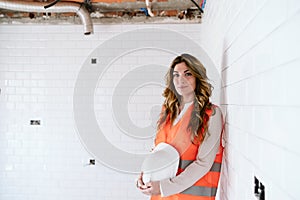 Inspector or architect professional woman holding helmet checking kitchen at construction site