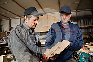 Inspector and carpenter in the carpentry workshop