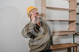 Inspector checking the construction site of a store while consulting by cell phone