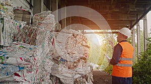 The inspector checks the pressed garbage at the waste recycling plant, waste recycling, sunset photo