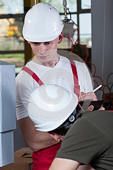 Inspector controlling worker at factory
