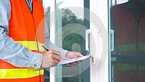 The inspector or engineer is inspecting the building structure and the glass door structure. After the renovation