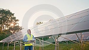 Inspector engineer man holding digital tablet working in solar panels power farm