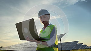 Inspector Engineer Woman Holding Digital laptop Working in Solar Panels Power Farm, Photovoltaic Cell Park, Green Energy