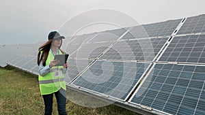 Inspector engineer woman walk on renewable energy station with digital tablet PC and check solar panels installation
