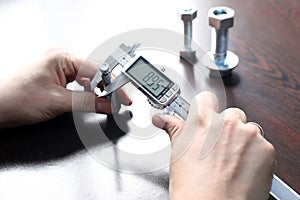 Inspector is measuring diameter of the bolts with a manual verniel caliper micrometer gauge. The Vernier caliper is an extremely.