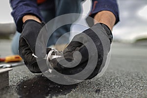 Inspector placing white yearly safety tag on to fall arrest fall restraint roof anchor point photo