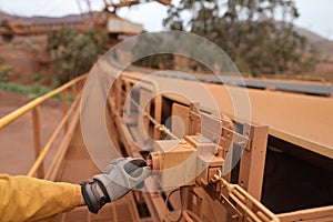 Inspector wearing safety glove inspecting emergency stop safety device system on conveyor belt