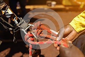 Inspector worker hand inspecting, tie, secure a low stretch red rope with  barrel knot on Aluminium full safety abseiling harness
