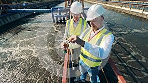 Inspectors are analyzing a water sample at the sewage cleaning site