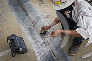 The inspectors are checking defect in welded of steel plate add joint with process Ultrasonic testing & x28;UT& x29;