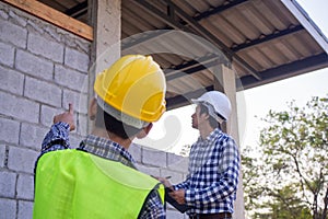 The inspectors are examining the structure of the house and note it in the clipboard to inform engineers to fix before selling to