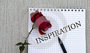 INSPIRATION - words on a white sheet of paper with a red rose on a gray background