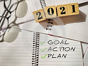 Inspirational concept - 2021 on wooden blocks. GOAL ACTION PLAN text written on notepad. Stock photo.