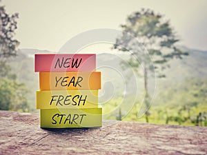 Inspirational Concept - NEW YEAR FRESH START text written on notepaper background. Stock photo.