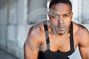 Inspirational exercise and fitness portrait of african american male athlete, intense and powerful expression in his eyes