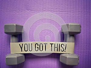 Inspirational Fitness Concept Quote - You got this. Text with exercise equipment background.