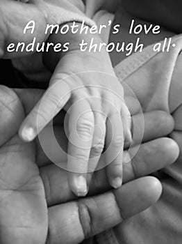 Inspirational mother quote- A mothers love endures through all. With blurry image of a fragile little baby new born hand and