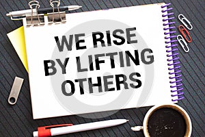 Inspirational and motivation life quote on notepad - We Rise by Lifting Others