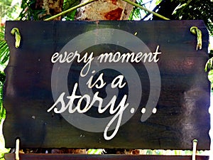 Inspirational motivation quote Every moment is a story on a sigh hanging in tree