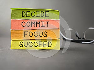 Inspirational and Motivational Concept - DECIDE COMMIT FOCUS SUCCEED text on colourful notepaper background. Stock photo.